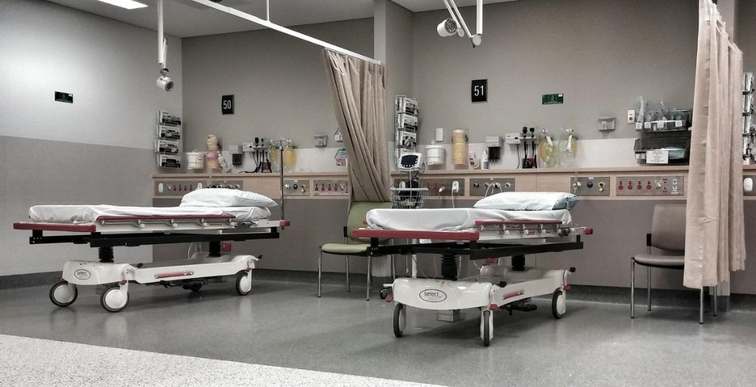 An empty hospital bay with two stretchers and equipment mounted on the wall