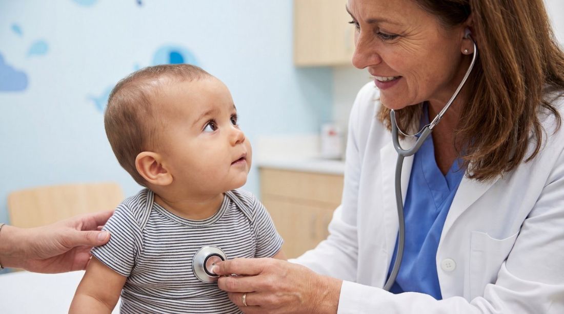 A doctor listening to a baby's chest with a stethoscope