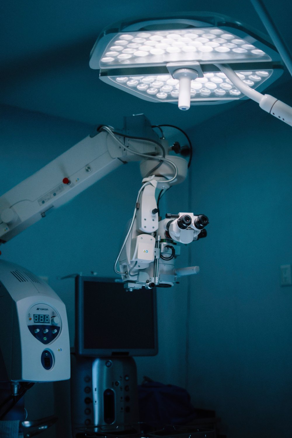 A ceiling-mounted surgical microscope and an operating lamp
